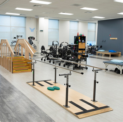 An open, well-lit room with an array of modern rehabilitative equipment.